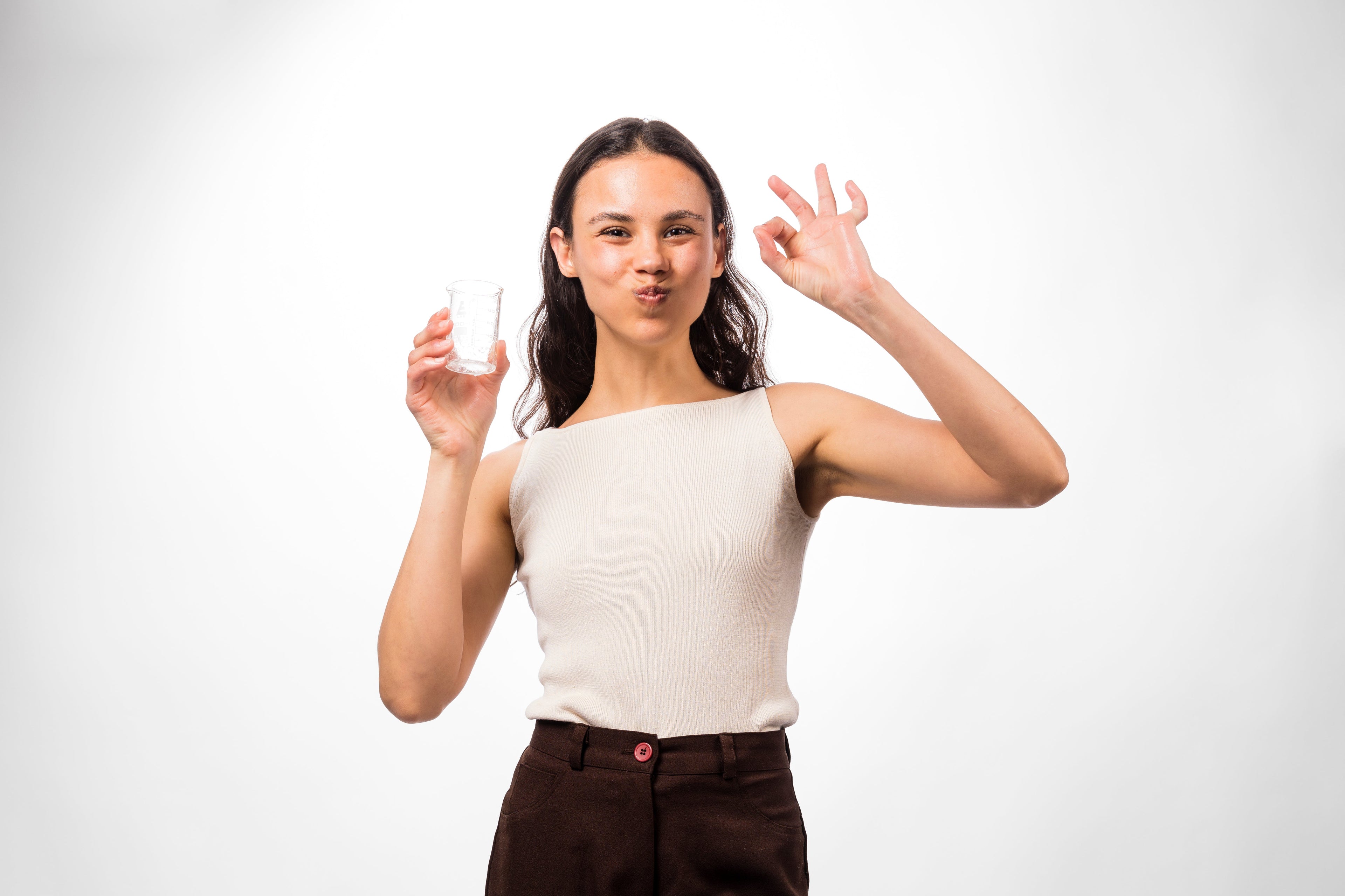 Woman holding a small white object against a plain background